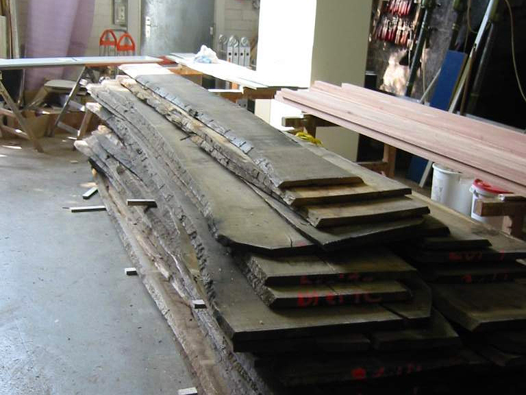 Sind die Bretter fertig zur weiteren Bearbeitung, werden sie uns geliefert. Noch ist an den Brettern die Baumrinde deutlich sichtbar.